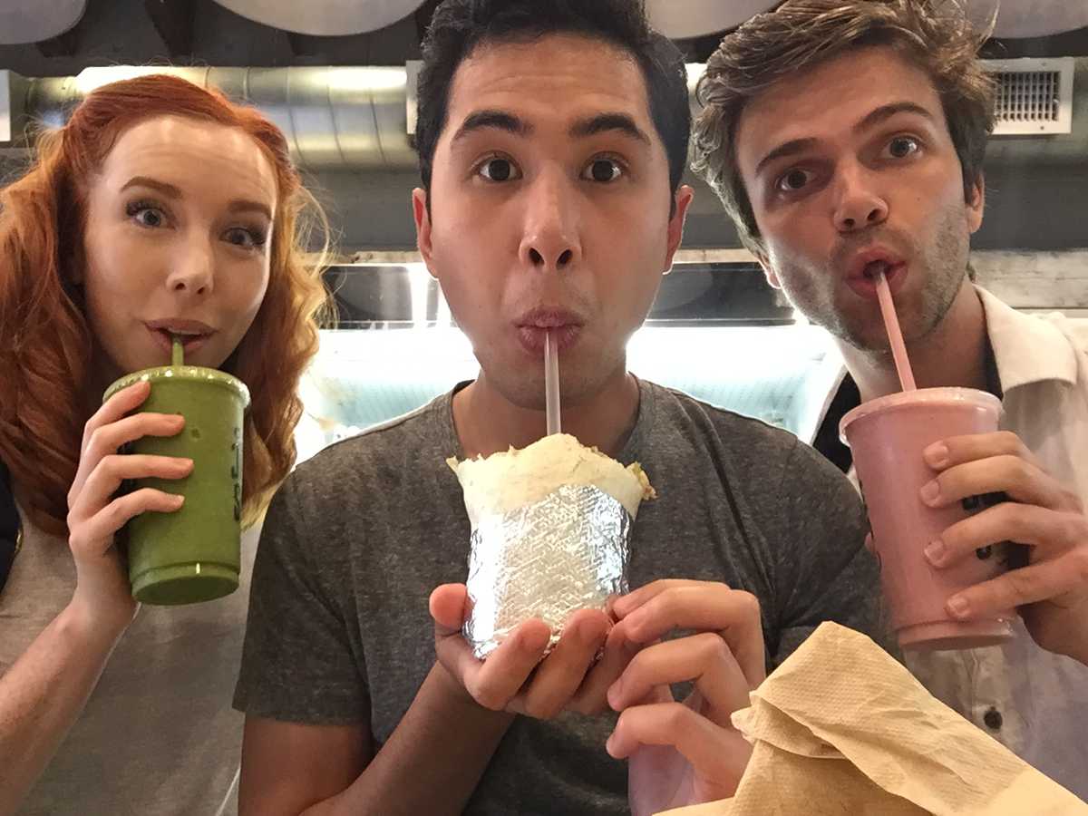Katie and Adrien drinking smoothies, while Mike drinks a burrito.